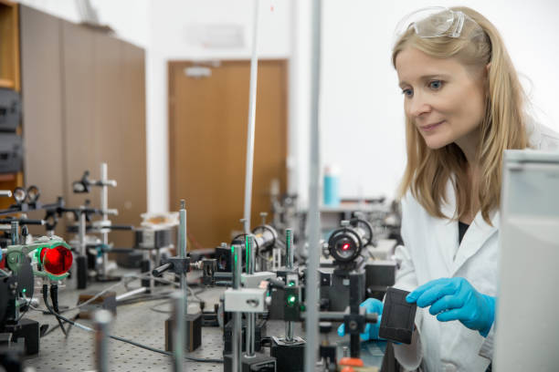Adult Female Researcher Assembling Laser Experimentation Platform.